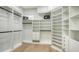 Spacious walk-in closet with custom shelving, drawers and wooden floors at 9818 Old Hyde Park Pl, Bradenton, FL 34202