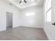 Bright bedroom featuring gray wood floors, tray ceiling, and windows for natural light at 10 Mast Dr # 1, Placida, FL 33946