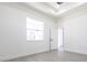 Bright bedroom featuring gray wood floors, tray ceiling, and windows for natural light at 10 Mast Dr # 1, Placida, FL 33946