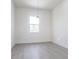 Bright bedroom featuring gray wood floors, a large window, and modern light fixture at 10 Mast Dr # 1, Placida, FL 33946