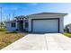 Modern single-story home featuring a two-car garage, covered entry, and a concrete driveway at 10 Mast Dr # 1, Placida, FL 33946