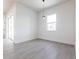 Bright, minimalist living room with gray wood floors and large sliding glass doors at 10 Mast Dr # 1, Placida, FL 33946