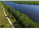 Aerial view showcasing a winding waterway bordered by a landscaped walking path at 10494 Atenia St, Port Charlotte, FL 33981