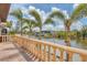 A backyard patio overlooking a canal with palm trees, lush greenery, and a boat dock at 10494 Atenia St, Port Charlotte, FL 33981