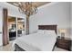 Cozy bedroom with a chandelier, side table, and sliding door to the outdoor patio at 10494 Atenia St, Port Charlotte, FL 33981