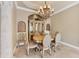 Dining room features an elegant chandelier, ornate china cabinet, and neutral color scheme at 10494 Atenia St, Port Charlotte, FL 33981