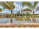 Scenic view of a dock on the water, framed by palm trees and greenery at 10494 Atenia St, Port Charlotte, FL 33981