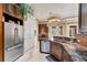 Kitchen features a granite countertop, stainless steel appliances, and dark wood cabinets at 10494 Atenia St, Port Charlotte, FL 33981