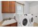 Well-equipped laundry room with modern washer, dryer, sink, and storage cabinet at 10494 Atenia St, Port Charlotte, FL 33981