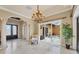 Open living room with tile floors, chandelier, and a sliding door to the patio at 10494 Atenia St, Port Charlotte, FL 33981