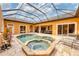 Aerial view of a screened-in pool with a hot tub and patio furniture at 10494 Atenia St, Port Charlotte, FL 33981