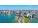 Aerial view of condo buildings near the beach with palm-lined streets and city views at 11 Sunset Dr # 303, Sarasota, FL 34236