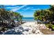 Beach access with a trail of foliage leading to the sandy beach and blue ocean at 11 Sunset Dr # 303, Sarasota, FL 34236