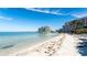 Scenic beach view with clear waters and modern condo buildings in the distance at 11 Sunset Dr # 303, Sarasota, FL 34236