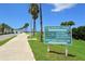 Sign for Causeway Park and Tony Saprito Fishing Pier with a palm tree lined road at 11 Sunset Dr # 303, Sarasota, FL 34236