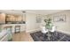 Bright dining area with glass table, upholstered chairs, and an open view into the modern kitchen at 11 Sunset Dr # 303, Sarasota, FL 34236