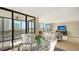 Light filled dining and living area with floor-to-ceiling windows and sliding glass doors to the balcony at 11 Sunset Dr # 303, Sarasota, FL 34236