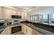 Well-lit kitchen featuring stainless steel appliances, granite countertops, and ample cabinet space at 11 Sunset Dr # 303, Sarasota, FL 34236
