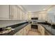 Well-equipped kitchen featuring dark granite countertops, stainless steel appliances, and cream cabinets at 11 Sunset Dr # 303, Sarasota, FL 34236
