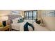 Stylishly furnished main bedroom featuring a luxurious upholstered bed, cozy armchair, and sliding glass doors to the balcony at 11 Sunset Dr # 303, Sarasota, FL 34236