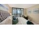 Beautifully decorated main bedroom featuring an upholstered bed, cozy armchair, and sliding glass doors to the balcony at 11 Sunset Dr # 303, Sarasota, FL 34236
