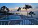 Beautiful waterfront pool and beach area at sunset with lounge chairs and palm trees at 11 Sunset Dr # 303, Sarasota, FL 34236