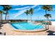Community pool with lounge seating, ocean views, palm trees, and handicap rail at 11 Sunset Dr # 303, Sarasota, FL 34236