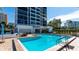 Community pool area with clear blue water and surrounding building at 11 Sunset Dr # 303, Sarasota, FL 34236