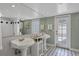 Elegant bathroom boasting double pedestal sinks, tiled floors, and modern fixtures at 1231 S Orange Ave, Sarasota, FL 34239