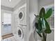 Well-organized laundry room with stacked washer and dryer, white cabinets, and a window at 1231 S Orange Ave, Sarasota, FL 34239
