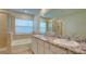 Bathroom features granite counters, double sinks, a bathtub, and a separate shower at 12534 Nantahala Run Run, Parrish, FL 34219