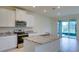 Well-equipped kitchen featuring stainless steel appliances, granite countertops, and a view of the sunroom at 12534 Nantahala Run Run, Parrish, FL 34219