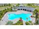 Aerial view of a community pool surrounded by palm trees, lounge chairs, and lush landscaping at 12534 Nantahala Run Run, Parrish, FL 34219