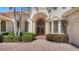 Arched entry and brick pathway lead up to front door of home with stately pillars and pristine landscaping at 12707 Deacons Pl, Lakewood Ranch, FL 34202