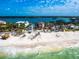 Aerial view of beachfront homes with solar panels, palm trees, and scenic ocean views from white sandy beaches at 1304 Casey Key Rd, Nokomis, FL 34275