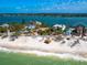 Breathtaking beachfront home surrounded by lush landscaping and pristine turquoise waters at 1304 Casey Key Rd, Nokomis, FL 34275