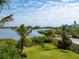 Lush backyard with green grass and mature trees, extending to the serene waterfront at 1304 Casey Key Rd, Nokomis, FL 34275