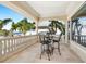 Covered balcony with dining table and chairs offers partial views of a tropical beach at 1304 Casey Key Rd, Nokomis, FL 34275