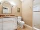 Stylish bathroom with a patterned wall, single sink, a toilet, and a walk-in shower at 1304 Casey Key Rd, Nokomis, FL 34275