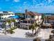 Exterior aerial view of a multi-story home surrounded by palm trees and neighboring constructions with blue skies at 1304 Casey Key Rd, Nokomis, FL 34275