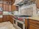 Close up on gourmet kitchen featuring stainless steel range, custom hood, and granite counters at 1304 Casey Key Rd, Nokomis, FL 34275