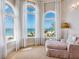 Relaxing living room offers stunning ocean views through large windows with sheer white curtains at 1304 Casey Key Rd, Nokomis, FL 34275