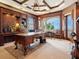 Executive office space featuring custom wood built-ins, a spacious desk, and scenic balcony access at 1304 Casey Key Rd, Nokomis, FL 34275