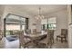 Dining room with chandelier, table seating for six, and sliding glass doors with outside seating at 13440 Esposito St, Venice, FL 34293