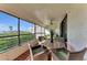 Relaxing screened-in balcony offering serene views of the ocean and lush tropical landscaping at 1465 Gulf Of Mexico Dr # 104, Longboat Key, FL 34228