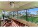 Spacious screened-in balcony with stylish furniture, offering serene views of the tropical surroundings and ocean at 1465 Gulf Of Mexico Dr # 104, Longboat Key, FL 34228