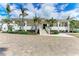 Elegant clubhouse exterior with palm trees, manicured landscaping, and a welcoming entrance for residents at 1465 Gulf Of Mexico Dr # 104, Longboat Key, FL 34228
