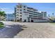 Exterior angle of a modern condo building with private garage spaces and multiple levels of balconies at 1465 Gulf Of Mexico Dr # 104, Longboat Key, FL 34228