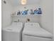 Well-equipped laundry room with washer, dryer, and storage shelves for convenience and organization at 1465 Gulf Of Mexico Dr # 104, Longboat Key, FL 34228