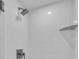 Modern bathroom with a shower featuring clean white tiles, sleek fixtures, and a built-in shelf at 1465 Gulf Of Mexico Dr # 104, Longboat Key, FL 34228